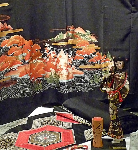 Japońska lalka na tle pięknego męskiego  kimona.
